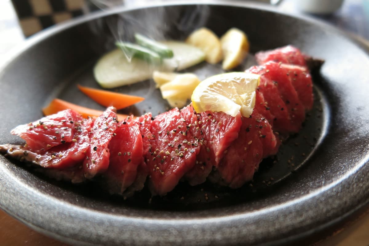 Sliced cooked steak with vegetables on a plate